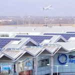 Rooftops of an airport with a plane in the background